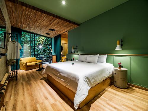 麦德林The Somos Bold Hotel的一间卧室设有一张大床和绿色的墙壁