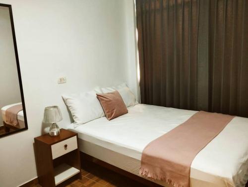 塔克纳Apart Florencia 2 con cochera!的一间卧室配有一张床和一个带灯的床头柜