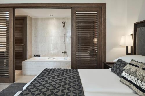 卡尔扎迈纳Atlantica Belvedere Resort - Adults Only的一间卧室设有一张大床和一个浴缸