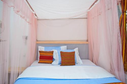 MbaleCitizen Cafe & Chambers的帐篷内的一张床位,上面有两个枕头
