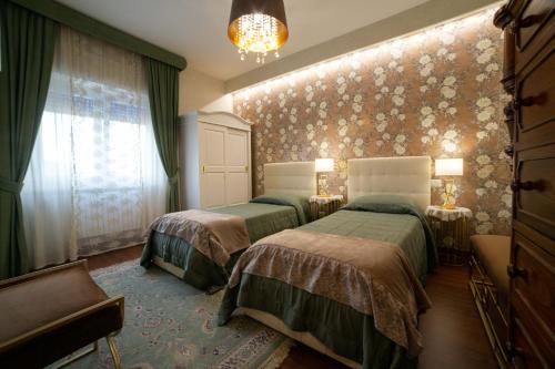 坎波巴索Dimora Giulia的一间卧室设有两张床和鲜花墙