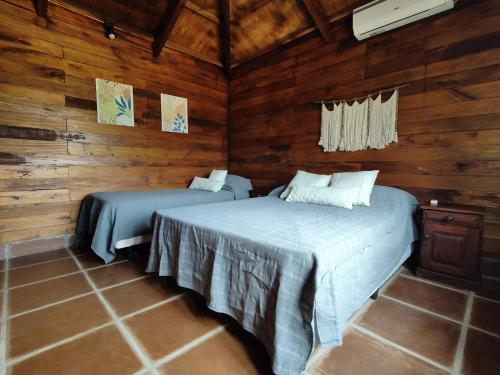 Coronel MoldesEl Cardon - Casa de Campo的木墙客房的两张床