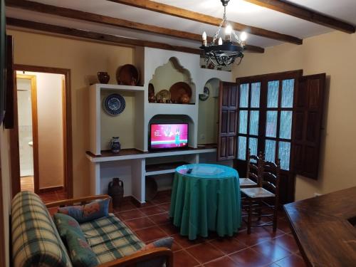 莫加拉斯El Humilladero的客厅配有桌子和电视