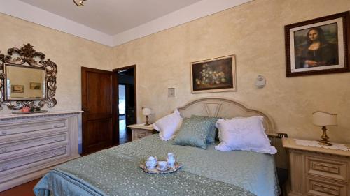 拉达-因基安蒂Angolino的一间卧室配有一张床、梳妆台和镜子