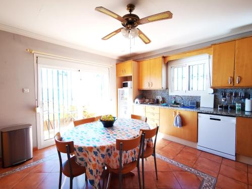 拉利内阿-德拉康塞普西翁Gibraltar Views Guest House的厨房配有桌子和吊扇