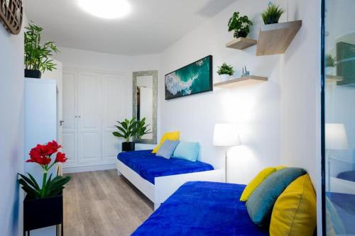 圣米格尔德阿沃纳GP127 apartman Tenerife的一间卧室配有两张带蓝色和黄色枕头的床