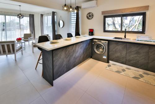 蒙舒瓦西OceanBreeze Apartments Mont Choisy的一间位于客房中间的厨房,配有一台洗衣机
