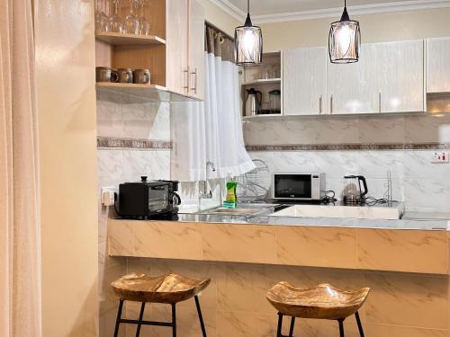 基塔莱Luxurious 2 bedroom penthouse-Fully Furnished at 360 Luxury的厨房配有带2把凳子的柜台