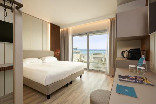 利多迪耶索罗亚得里亚海皇宫酒店的一间卧室配有一张床,享有海景