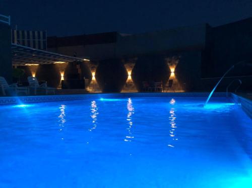 Al KarāmahCali Chalet的夜晚的游泳池,灯光蓝色