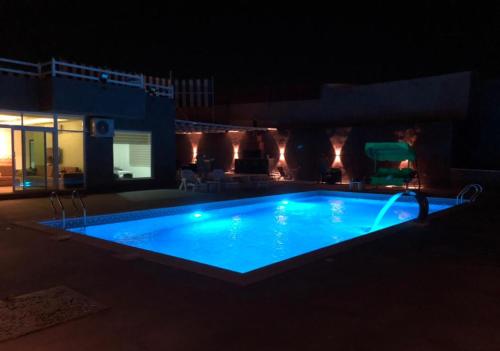 Al KarāmahCali Chalet的游泳池在晚上点亮