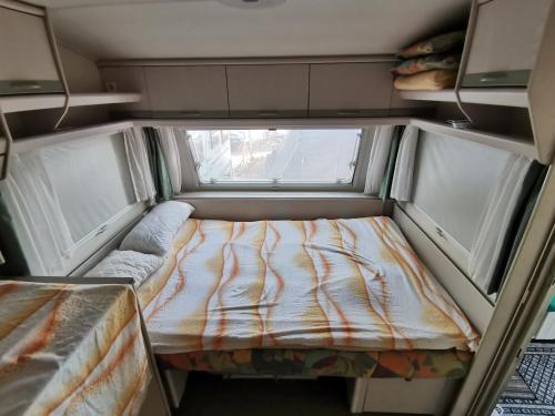 乌格连Room in Cabin - Caravan near the sea 5的小房间设有床和2个窗户