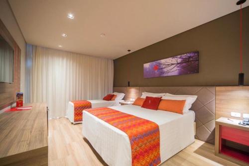 格拉玛多Hotel Laghetto Stilo Borges apt 318的一间酒店客房,设有两张床和电视