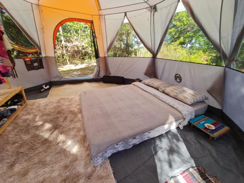 伊塔卡雷Que Brota Do Chão的帐篷内一间卧室,配有一张床