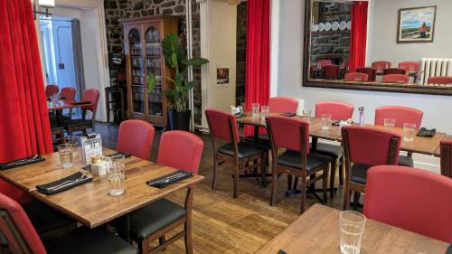 蒙马尼La Maison Rousseau的餐厅设有木桌和红色椅子