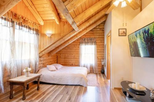 TunkhannockCharming Rustic Cabin 3,600sf with Private Pool, Hot Tub & Sauna!的小木屋内的卧室,配有一张床和一张桌子