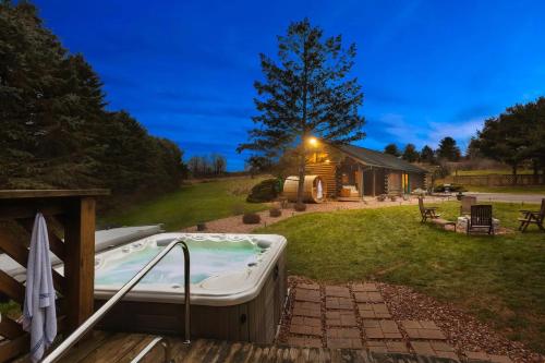 TunkhannockCharming Rustic Cabin 3,600sf with Private Pool, Hot Tub & Sauna!的小屋的庭院里设有一个按摩浴缸