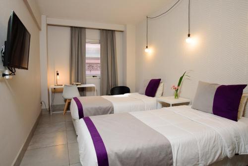 布宜诺斯艾利斯M Concept Hotel的酒店客房设有两张床和一张桌子。