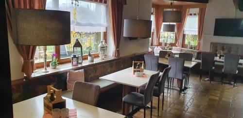 洛伊塔施Pension Gasthof Gaistal的餐厅设有桌椅和窗户。