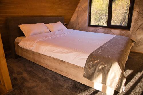 百乐·奥拉内斯蒂Cabana AFrame Olanesti的窗户客房内的一张大床