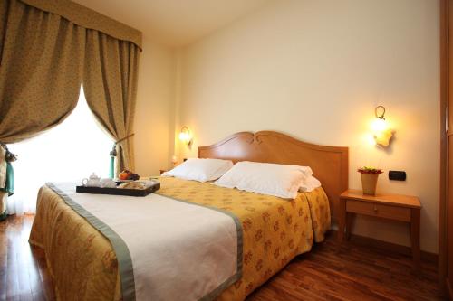 阿尔蒙诺圣巴特鲁姆卡莫乐堤酒店的一间卧室设有一张大床和大窗户