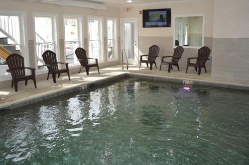 旧奥查德比奇科普利拉瑞恩汽车旅馆的一组椅子和一座房子里的游泳池