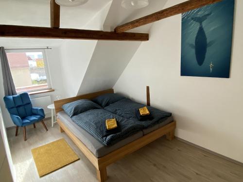 耶拿Ferienwohnung Happynest的一间卧室配有一张床和一张蓝色椅子