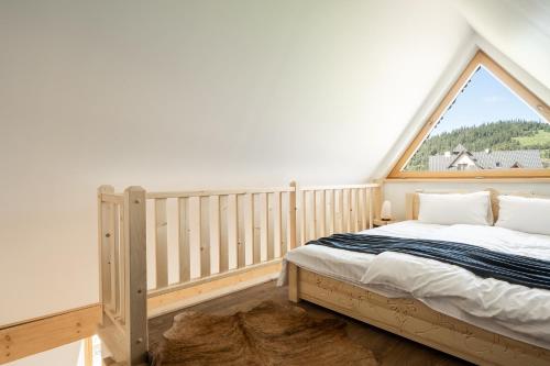 波罗宁Zacny Lasek的一间卧室设有一张床和一个大窗户