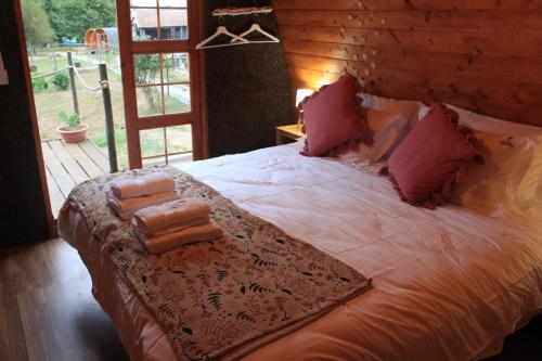 帕科斯费雷拉Casa da Avó Miquinhas的卧室配有一张带粉红色枕头的大床