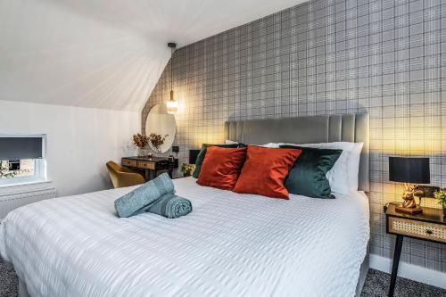 邓弗姆林Parkside 2 bedroom house near Dunfermline & Edinburgh的卧室配有一张带彩色枕头的大型白色床。