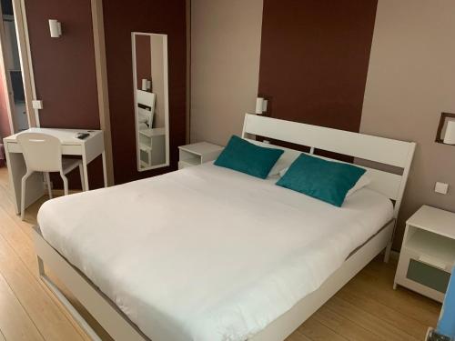 普罗旺斯艾克斯艾克斯酒店的卧室配有带蓝色枕头的大型白色床