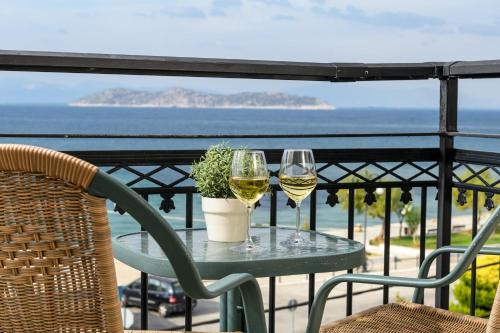 萨索斯Hotel Timoleon的阳台上的桌子上放着两杯葡萄酒