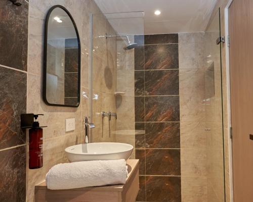 麦德林Elemont Hotel的浴室配有盥洗盆和带镜子的淋浴