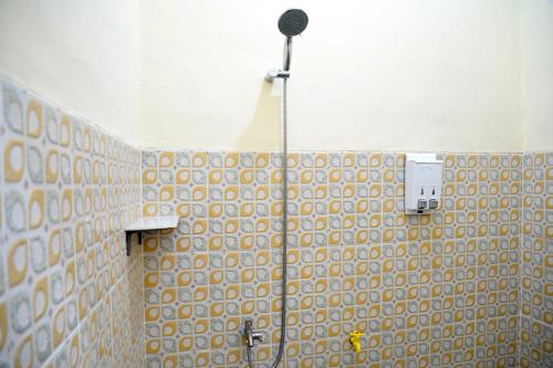 班达楠榜Haura syariah home stay的一间带淋浴的浴室和瓷砖墙