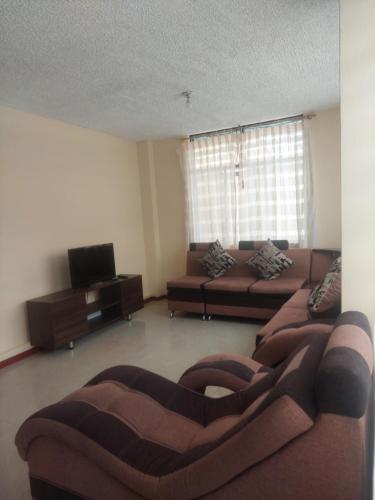 安巴托Departamento confortable cerca del Mall de los Andes的客厅配有两张沙发和一台电视机