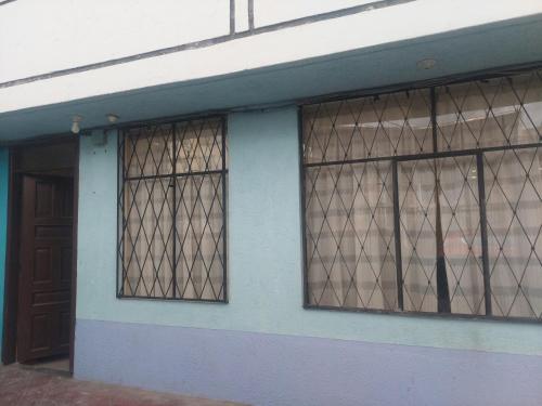 安巴托Departamento confortable cerca del Mall de los Andes的一座带两扇窗户和一扇门的建筑