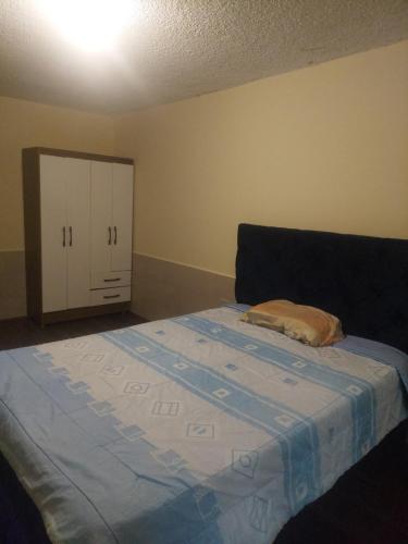 安巴托Departamento confortable cerca del Mall de los Andes的一间卧室配有一张床和一个橱柜