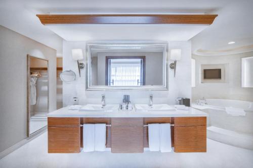 长沙长沙运达喜来登酒店的浴室设有2个水槽、镜子和浴缸。