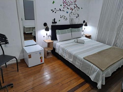 里约热内卢Sobrado Botafogo的一间卧室配有一张大床和一把椅子