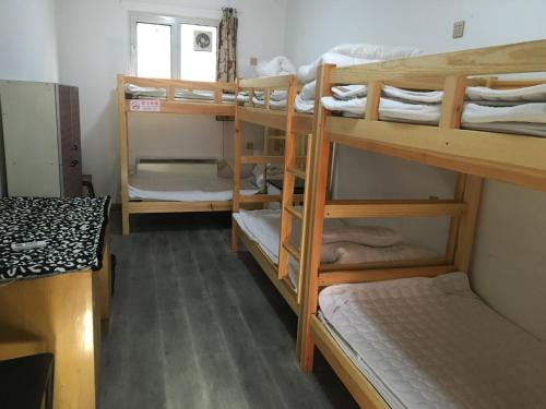 北京P.Loft Youth Hostel的客房设有三张双层床和一扇窗户。
