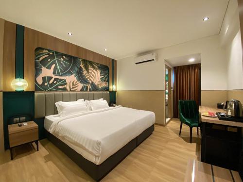 丹戎槟榔Alltrue Hotel Bintan - Tanjungpinang的一间卧室配有一张床和一张桌子及椅子