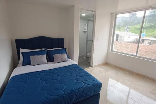 Santa Rosa de ViterboApartamento Nuevo y Central的一间卧室设有蓝色的床和大窗户