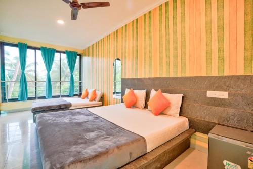 卡兰古特Swastic Hotel at Calangute GOA的一间卧室设有两张床和两个窗户。
