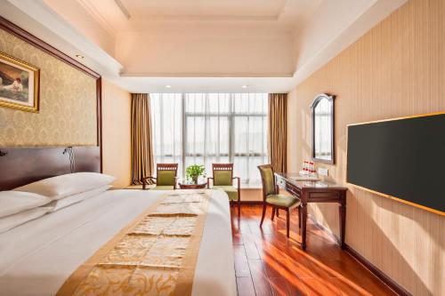 宝安Vienna Hotel Shenzhen International Airport的配有一张床和一台平面电视的酒店客房