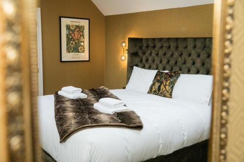 巴克斯顿Foxlow Grange By Muse Escapes的一间卧室配有一张带白色床单和毯子的床。