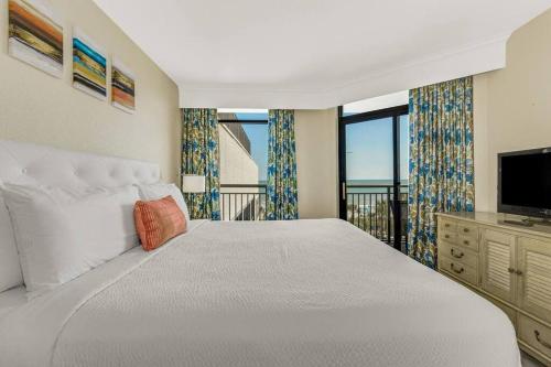 默特尔比奇Breathtaking Oceanfront 3BR,2BA Suite/Grand Cayman 451的一间卧室配有一张大床和电视