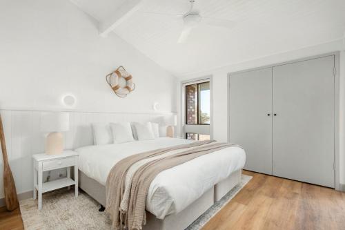 尼尔森湾Dutchies Motel Nelson Bay & Dutchmans Beach Apartments的白色的卧室设有一张大床和一个窗户