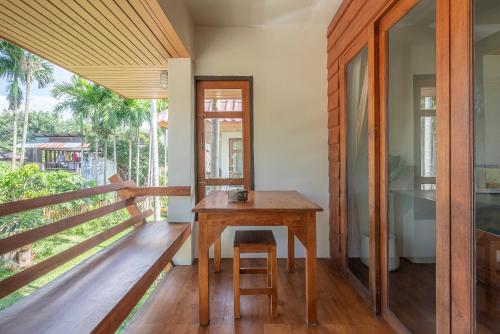 拜县Betel Palm Village - Casa Retreat的房屋阳台的木桌