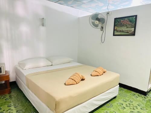皮皮岛Bang sit Guest House的一间卧室配有一张带两个羊角面包的床