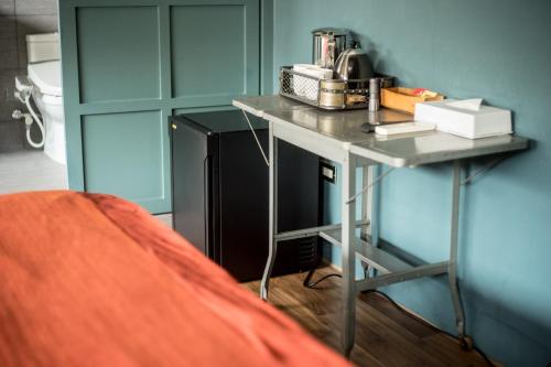 Hsin-ying未艾公寓WeLove Apartment的客房设有桌子和黑冰箱。